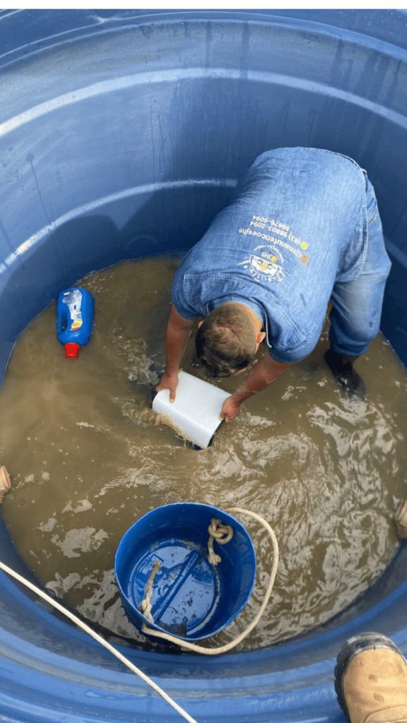 Técnico JHS realizando limpeza de reservatório